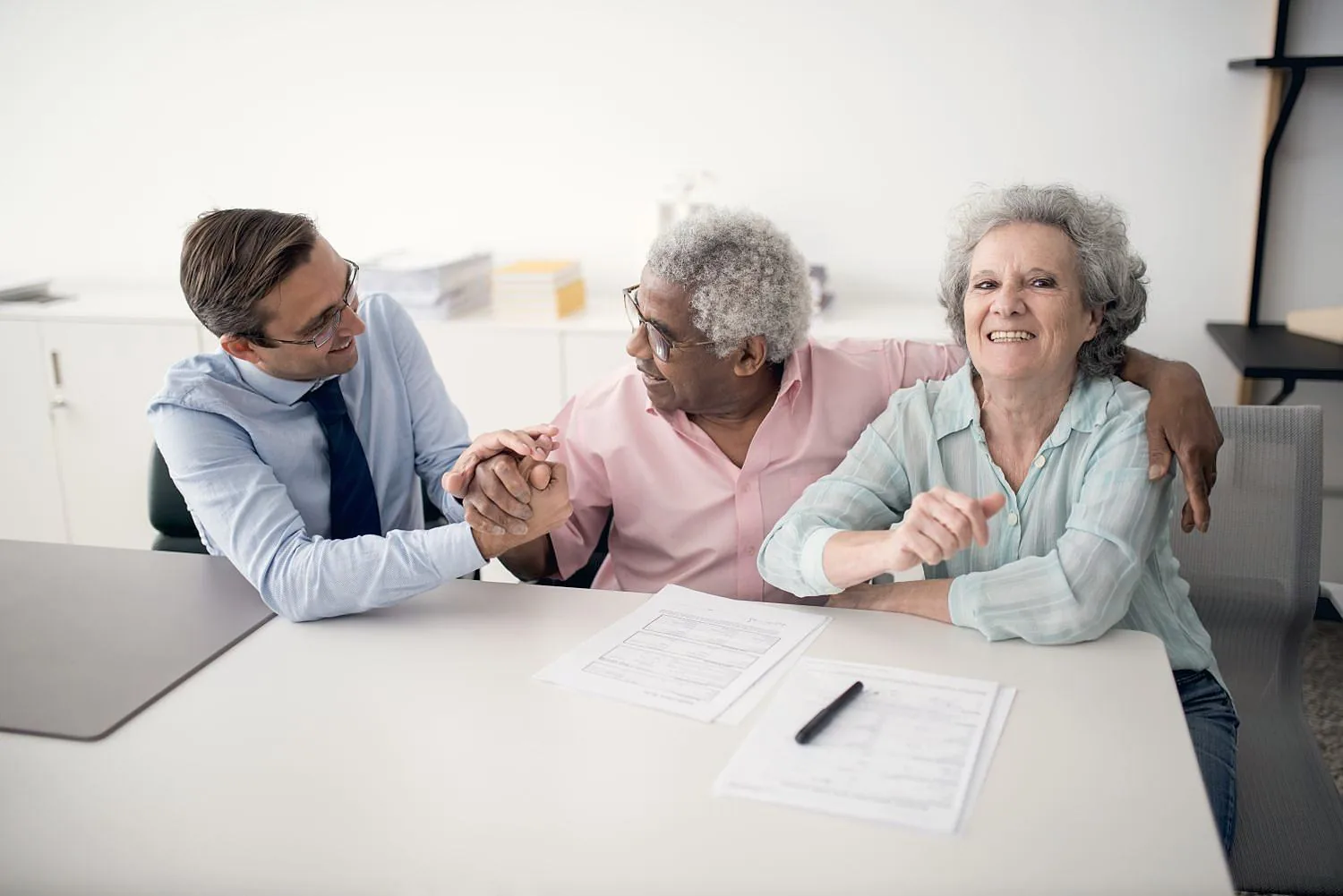 An associate reassuring an older couple across a table