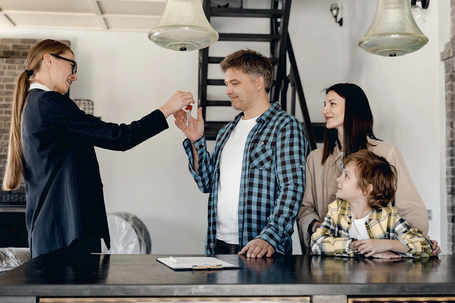 An associate handing house keys to a happy family