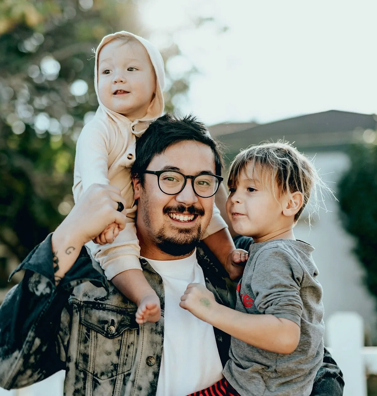 A parent outdoors with two children