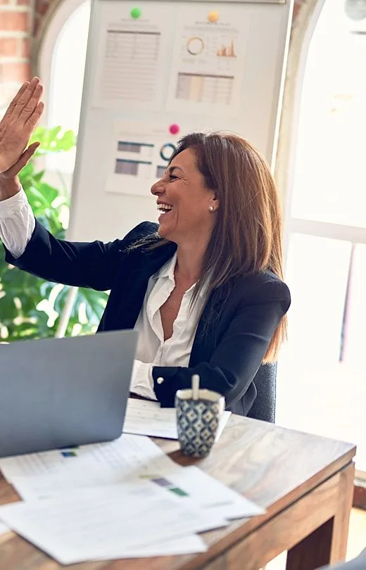 Two colleagues celebrating a win together in an office